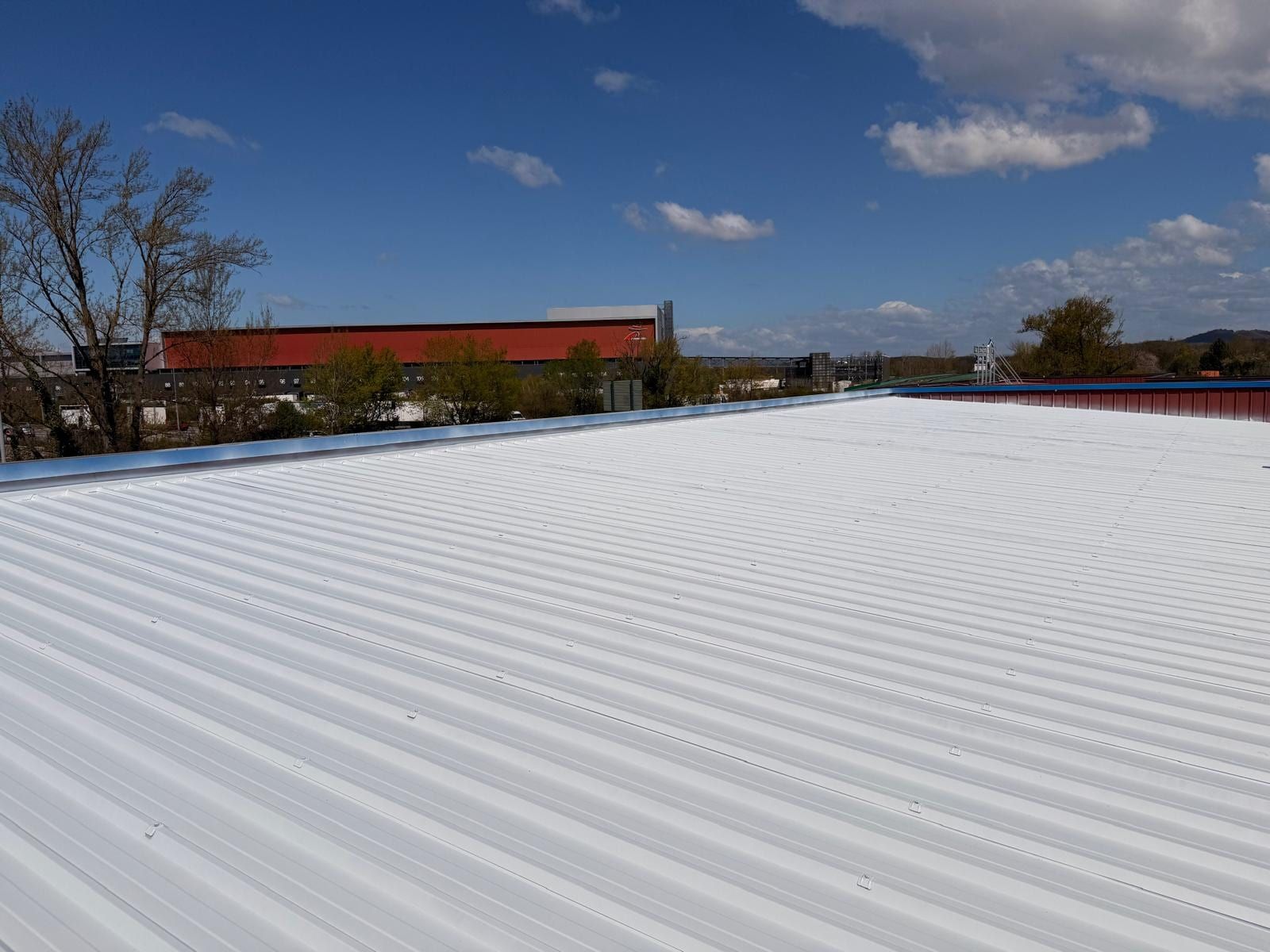 Corrugated steel deck coated reflective white, seen from the parapet
