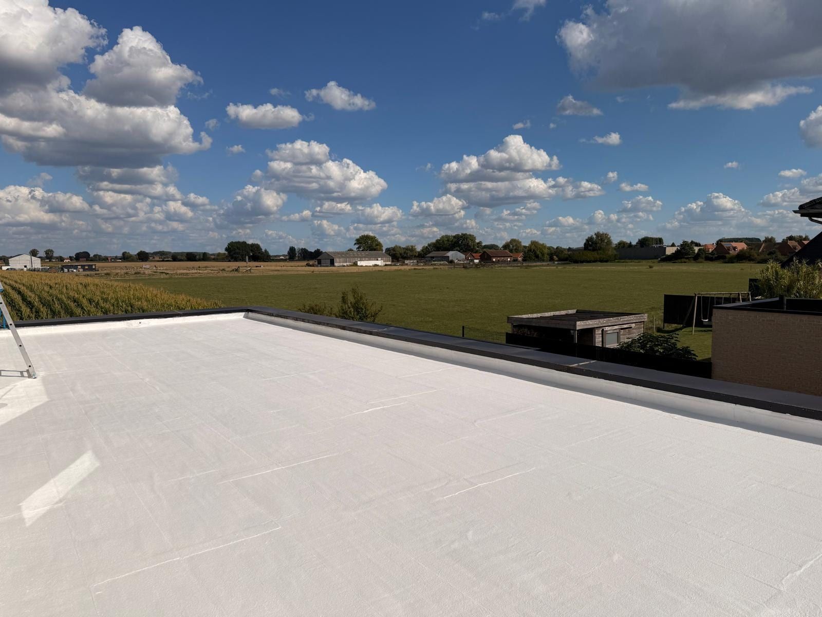 Flat roof coated reflective white, garden and countryside of northern France