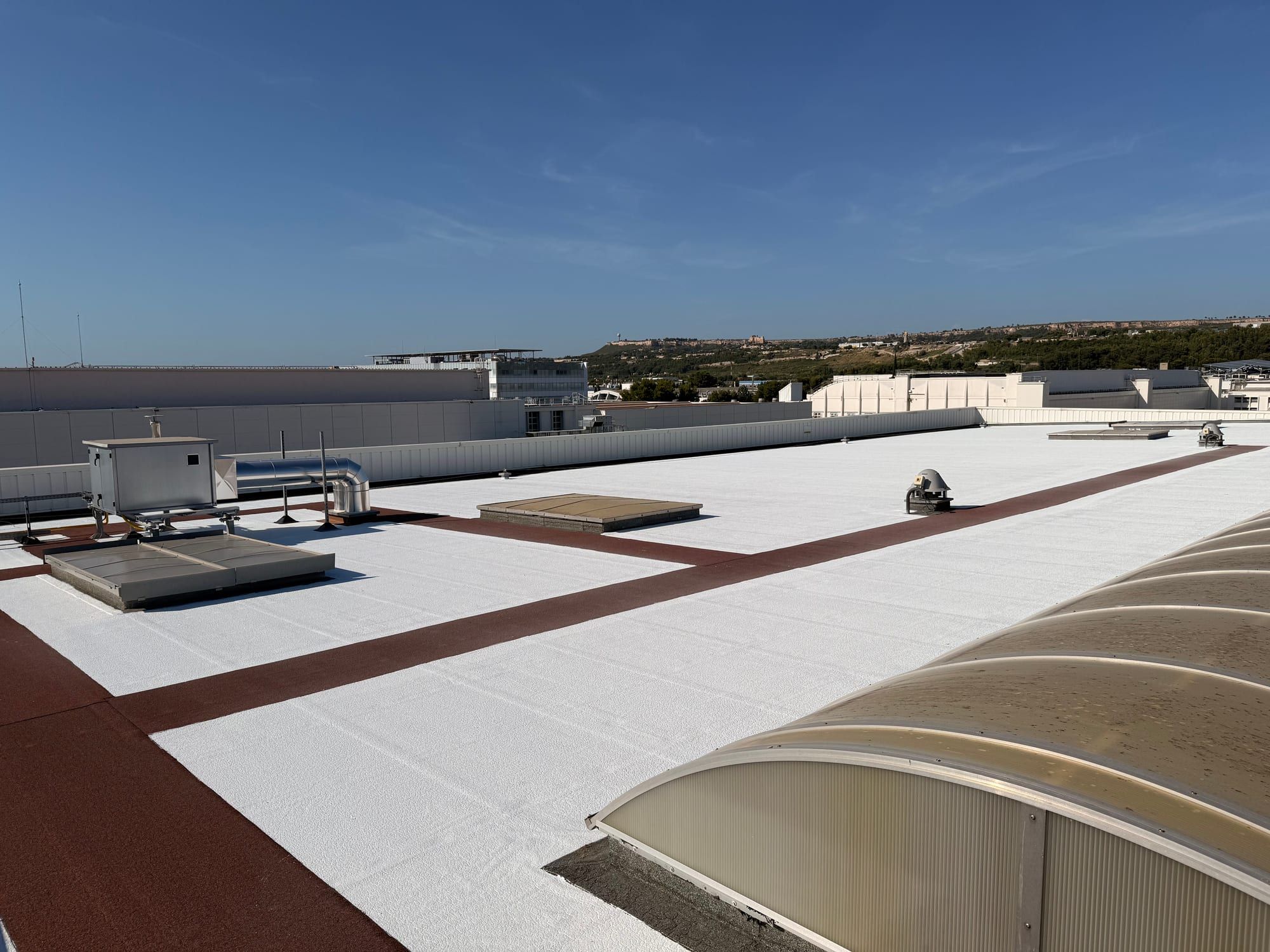 Treated roof with reflective white surface and preserved rooflights