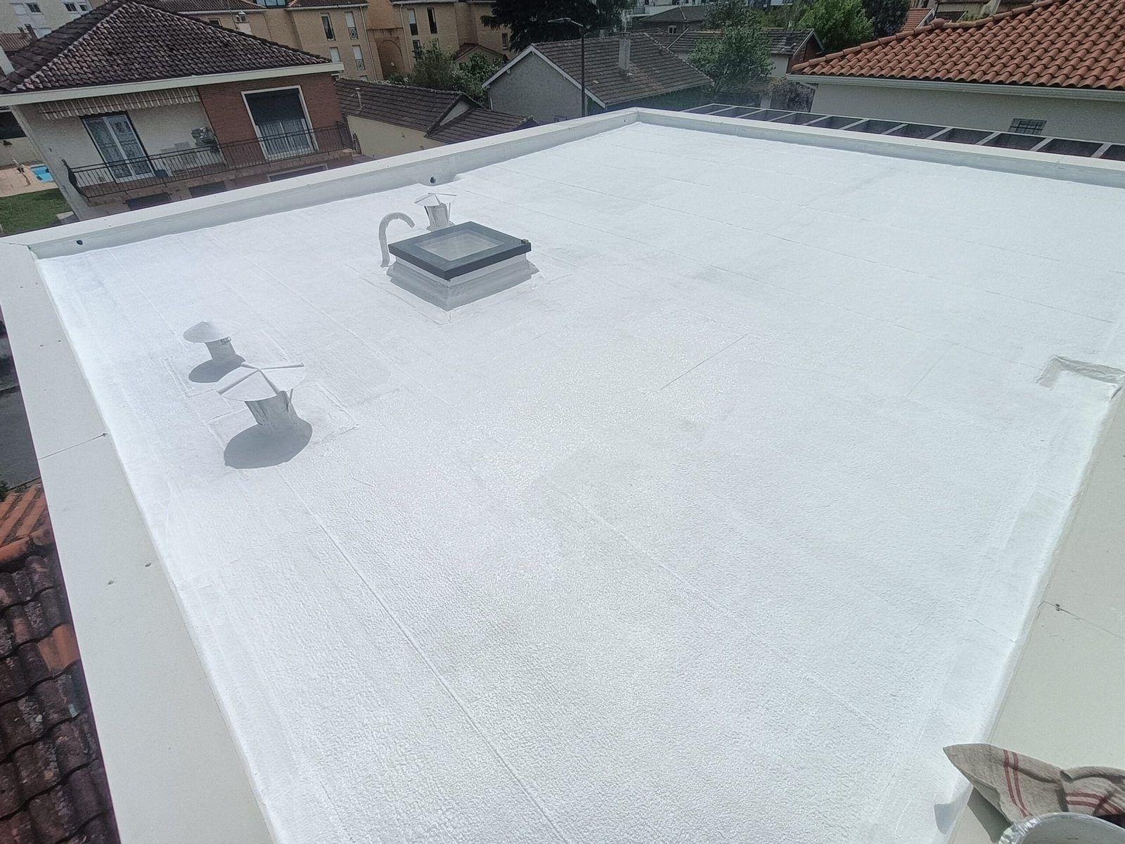 Toit plat d’une maison après application de la peinture cool roof PrimaTherm®, surface blanche réfléchissante