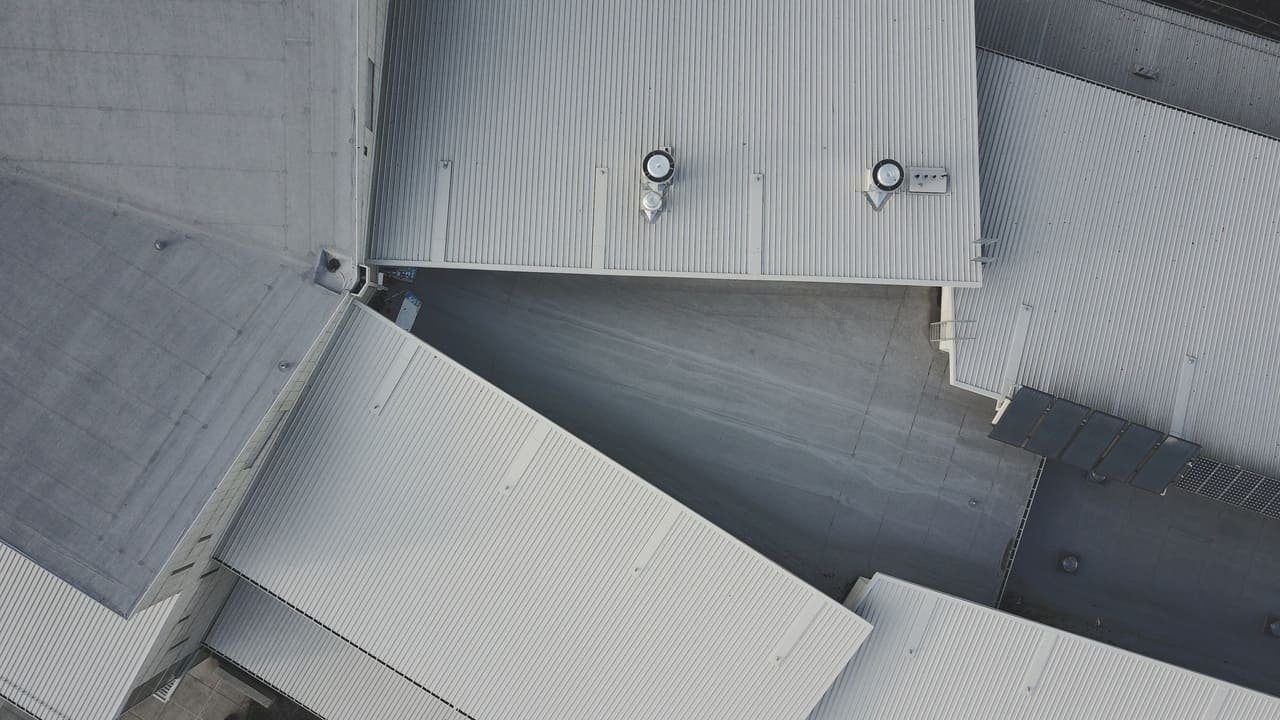 Grand bâtiment en bac acier à toiture claire, type hangar agricole ou de stockage